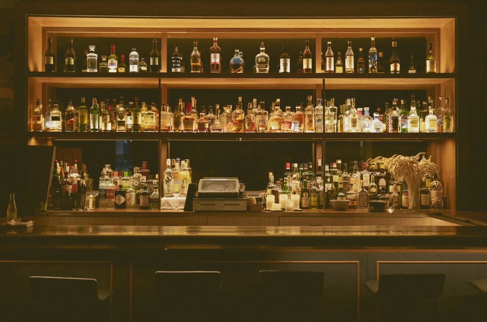 A wooden back-bar shelf lined with bottles