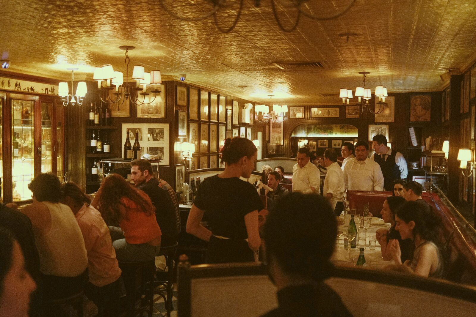 A crowded bistro dining room with guests seated at tables