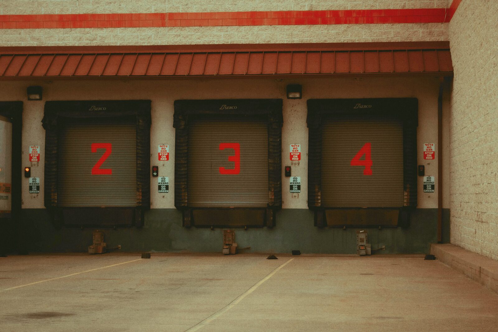 Three numbered loading dock bays on a warehouse exterior.