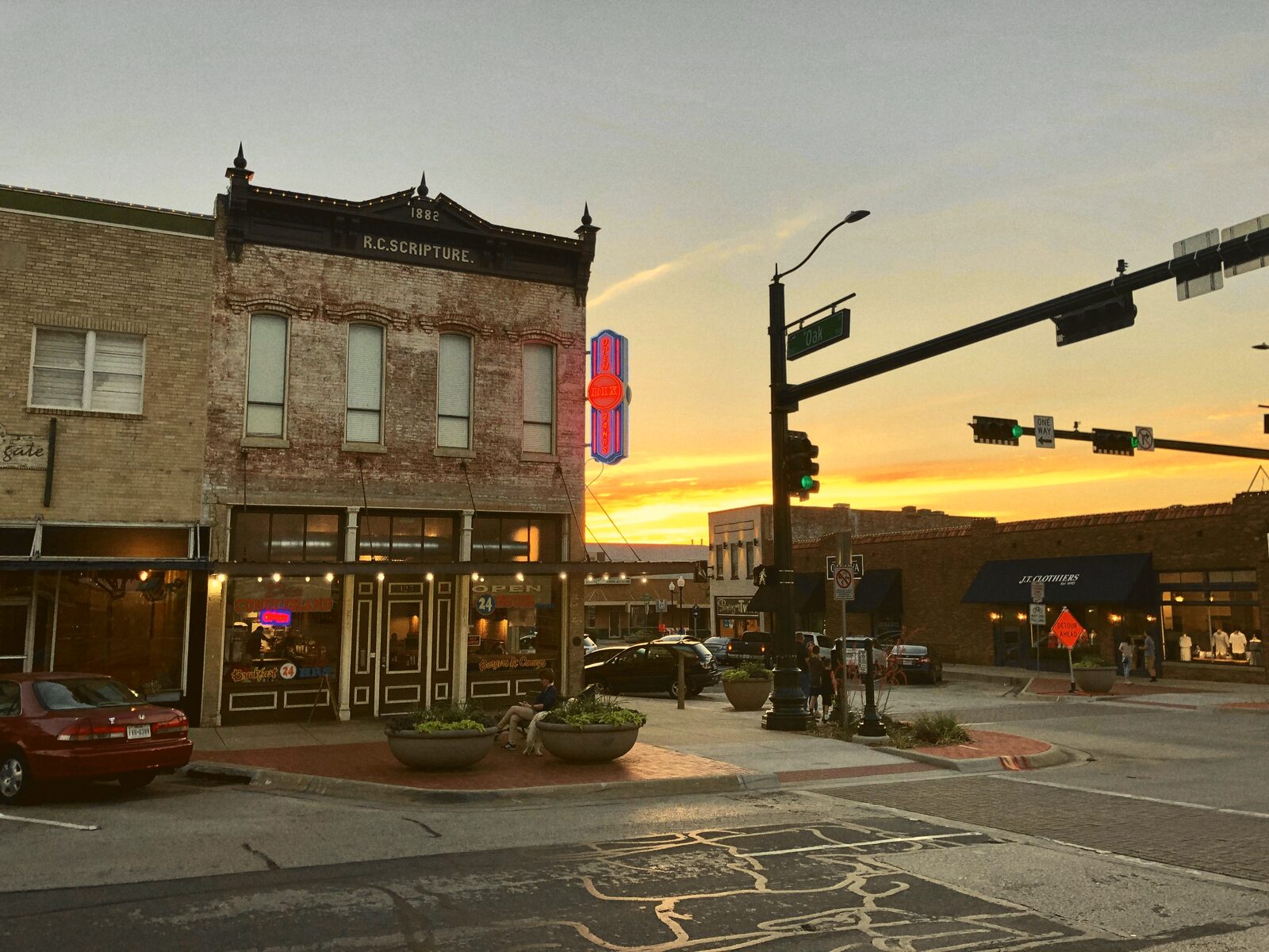 A small-town main street storefront lit up at sunset.