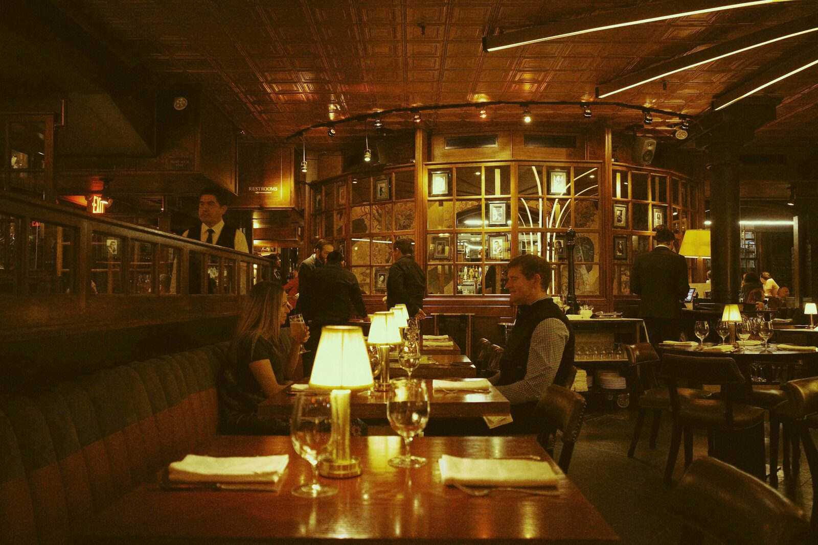A dimly lit tavern dining room with diners at tables