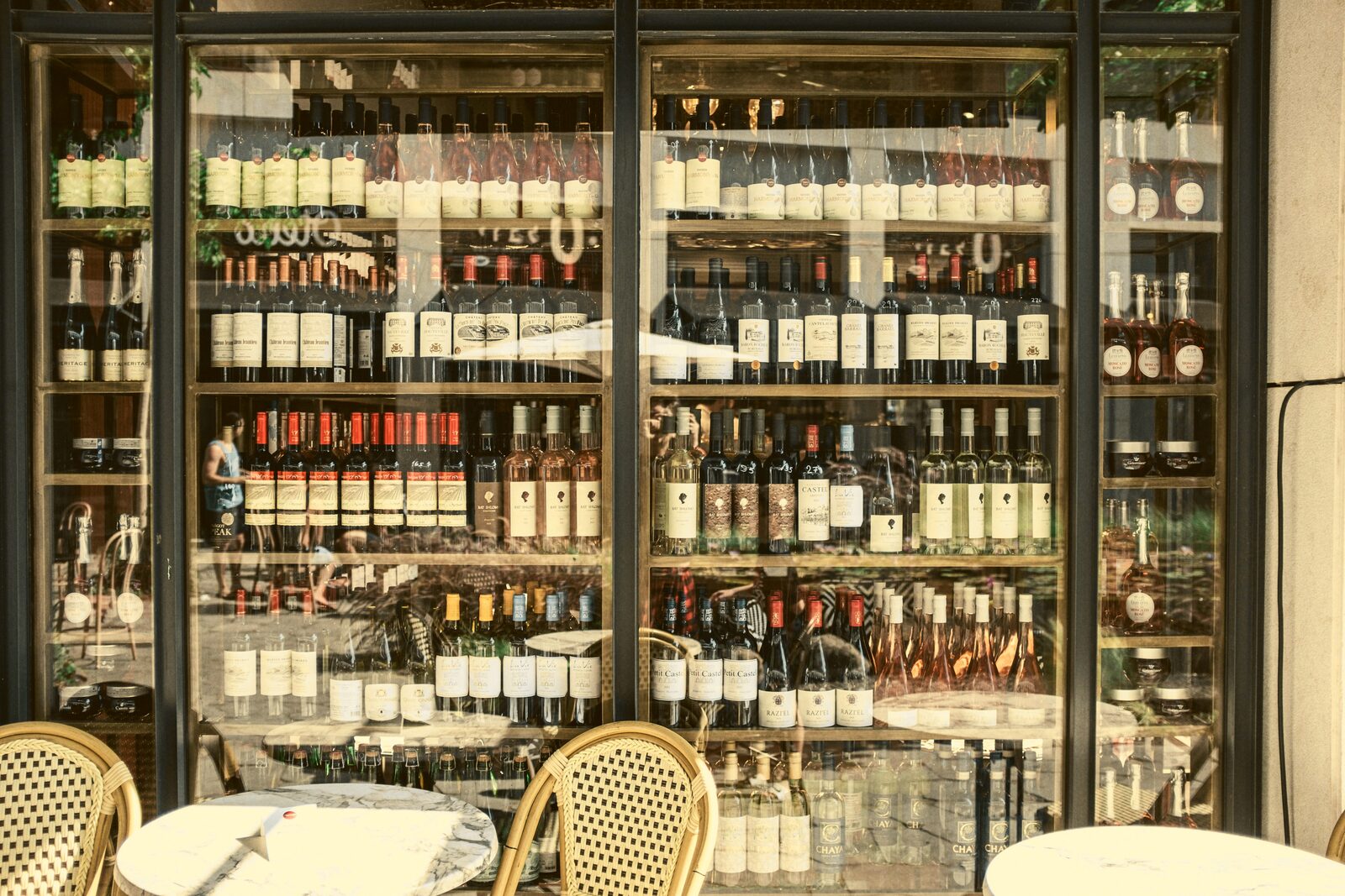 Illuminated glass display cases stocked with rows of wine bottles.